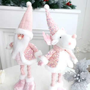 Pink Christmas gnome and white reindeer figures with sequins on white mantelpiece