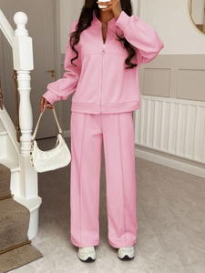 Detail of pink two-piece tracksuit featuring a zip-up hoodie and wide-leg trousers