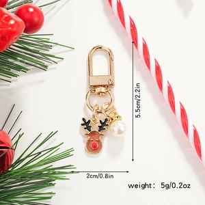 Detailed view of Christmas reindeer keychain with enamel finish and pearl charm detail