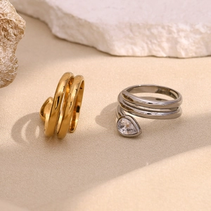 Detail of 18K gold and silver spiral snake head rings with pear-cut white zircon accent