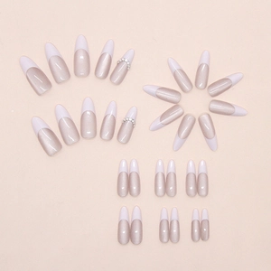 Detailed view of champagne cat-eye press-on nails with French tips and rhinestones