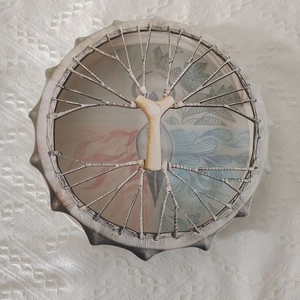 Detail of wooden shaman drum with patriotic leaf pattern and unique tree-shaped rope handle
