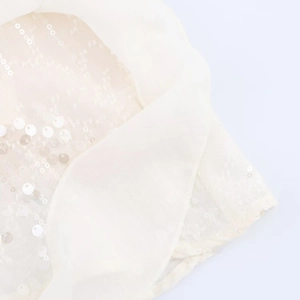 Détail de broderie de paillettes blanches sur mousseline pour une robe courte de printemps