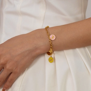 Detailed macro view of gold chain bracelet with colorful enamel butterfly charms on wrist
