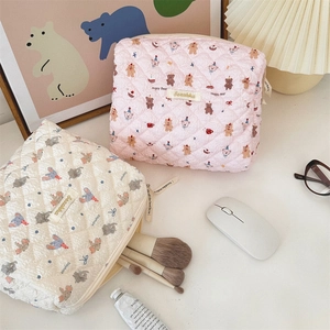 Detailed view of quilted cotton cosmetic bags with cute bear and elephant patterns