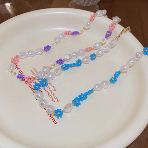 Elegant beaded necklace with colorful flower pearls on a vintage ceramic plate display