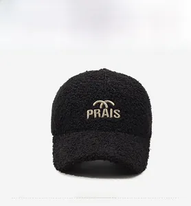 Gros plan sur la casquette en laine d'agneau noire avec broderie PRAIS blanche de qualité
