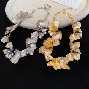 Detailed macro of gold and silver textured flower petal pendants on metal chains