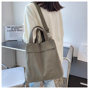 Army green nylon tote bag shown in a lifestyle setting with comfortable shoulder strap