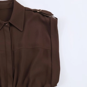 Detailansicht des dunkelbraunen Midikleids mit Schulterklappen und Metallringschnalle