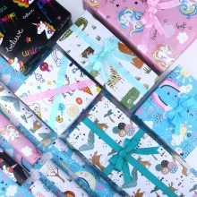 Flat lay of colorful gift boxes with unicorn and animal prints tied with ribbons