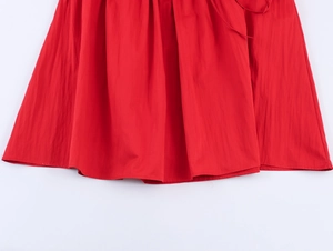Dettaglio delle pieghe sull'orlo e delle cuciture su questo abito midi rosso chic