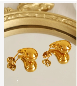 Macro shot of 18K gold plated teardrop stud earrings with a glossy mirror-like finish