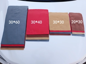 Microfiber car drying towels in multiple sizes and colors on a white car surface