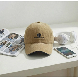 Close-up of khaki corduroy baseball cap with blue HB letter embroidery and sun visor detail