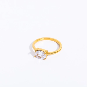 Detailed view of an oval-cut clear zircon stone in a 4-prong gold-plated ring setting