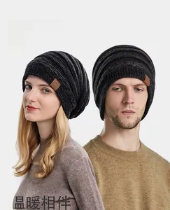Winter knit beanie on male and female models featuring black and grey marled knit texture