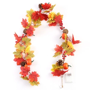 Detail of autumn wreath with maple leaves, sunflower, pumpkins, and warm LED light string