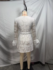 Detail showing white rose jacquard texture, flared cuffs and waist belt on the short dress