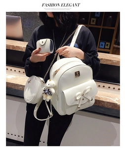 Three-piece beige backpack set with bow detail and bear charm shown on a model