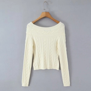 Gros plan sur un pull en maille crème à épaules dénudées avec torsades et détails boutonnés