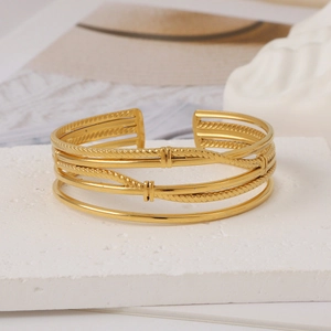 Detail view of gold adjustable cuff bracelet with multiple twisted wire patterns on stone