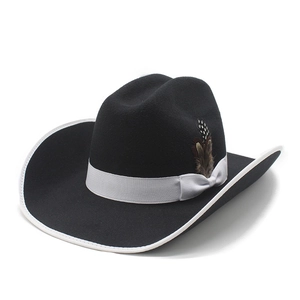 Detail of black felt cowboy hat featuring white silk ribbon trim and natural feather accents