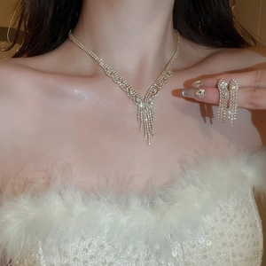 Luxurious gold plated necklace and earring set with shimmering zircon tassels on a model
