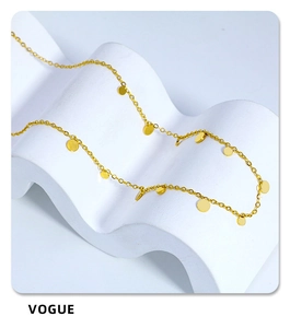 Macro shot of gold choker chain with disk charms resting on white artistic props