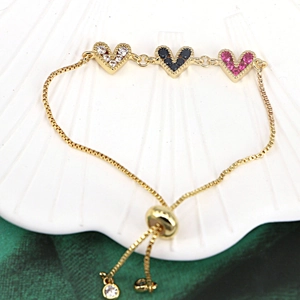 Detail of adjustable gold heart bracelet with multicolor cubic zirconia inlay