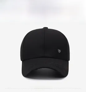 Vue détaillée de la casquette noire avec emblème en métal et coutures sur la visière courbe