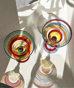 Top view of colorful striped cocktail glasses with artistic light shadow reflection