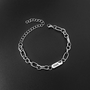 Detail of silver chain bracelet with rectangular metal plate engraved with love text