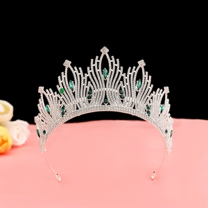 Macro view of luxury baroque crown with emerald green gems and white rhinestones