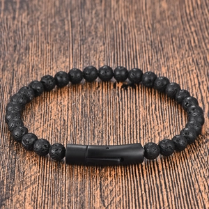 Minimalist black lava stone bead bracelet with a sleek magnetic clasp on a wood background