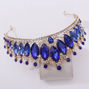 Detail of royal gold crown featuring deep blue marquise crystals and sparkling white gems