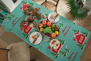 Teal Christmas tablecloth featuring red house prints and festive trees in a dining scene