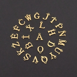 Macro detail of 26 golden heart alphabet charms for DIY pendant necklace jewelry making