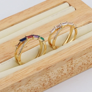 Close-up of gold double-band rings with colorful rectangular gemstones and pave diamonds