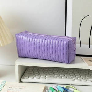 Detail of purple quilted pencil case with vertical stitching and smooth zipper closure