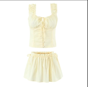 Two-piece floral crop top and skirt set in pale yellow with ruffle details and buttons