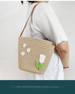Detail of handmade woven tote bag with white floral crochet and brown leather strap