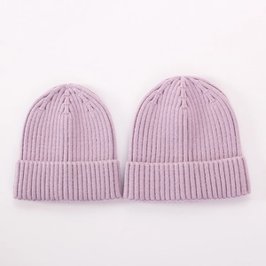 Detailed view of two purple ribbed knit beanies with ear flaps for babies and kids