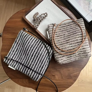 Detail of vintage striped wool crossbody phone bags in black and beige woven textures
