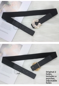 Detail of adjustable C-shaped rhinestone buckle on a black elastic waist belt with punch tool