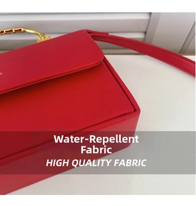 Détail du sac rouge en similicuir imperméable avec poignée dorée et décoration