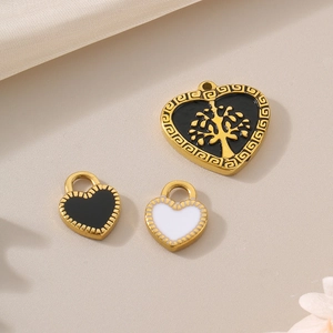 Three heart-shaped gold pendants with black and white enamel and Tree of Life motif