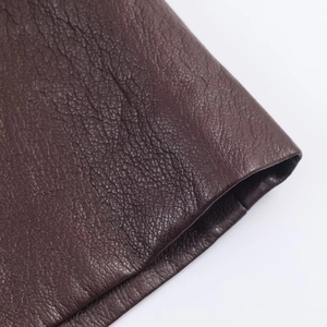 Dettaglio macro della texture in pelle marrone scuro con rifiniture dei bordi