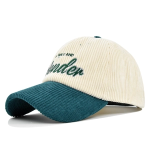 Detail view of corduroy baseball cap with 3D embroidery and contrasting green visor