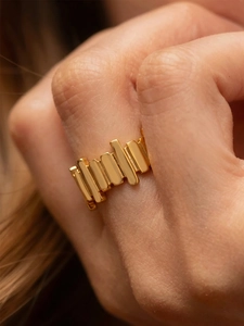 Macro shot of gold-plated stainless steel ring with vertical textured design on finger
